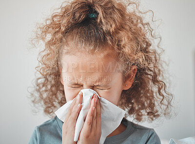 Buy stock photo Shot of a little sick girl blowing her nose at home