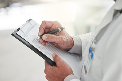 Buy stock photo Shot of an unrecognizable doctor writing of a form at a hospital