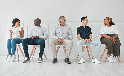 Buy stock photo Shot of a diverse group of people talking to each other while sitting in line against a white background
