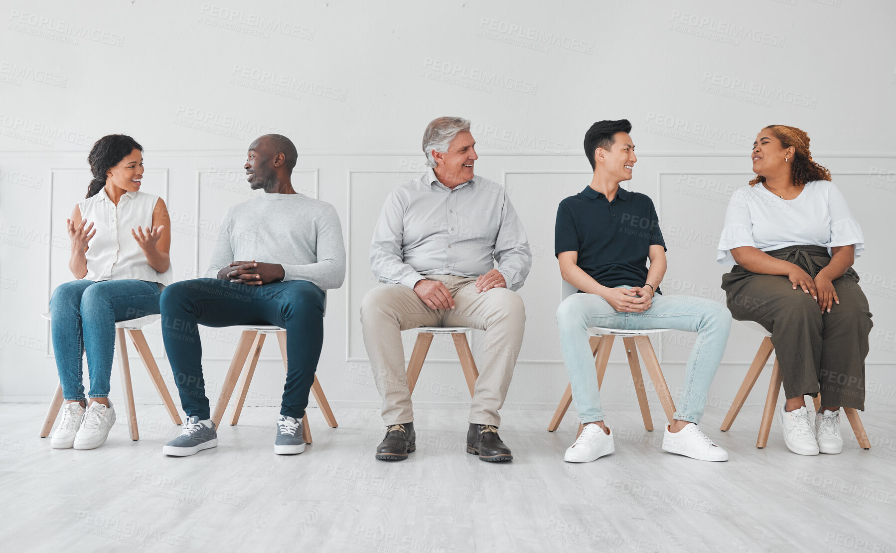 Buy stock photo Shot of a diverse group of people talking to each other while sitting in line against a white background