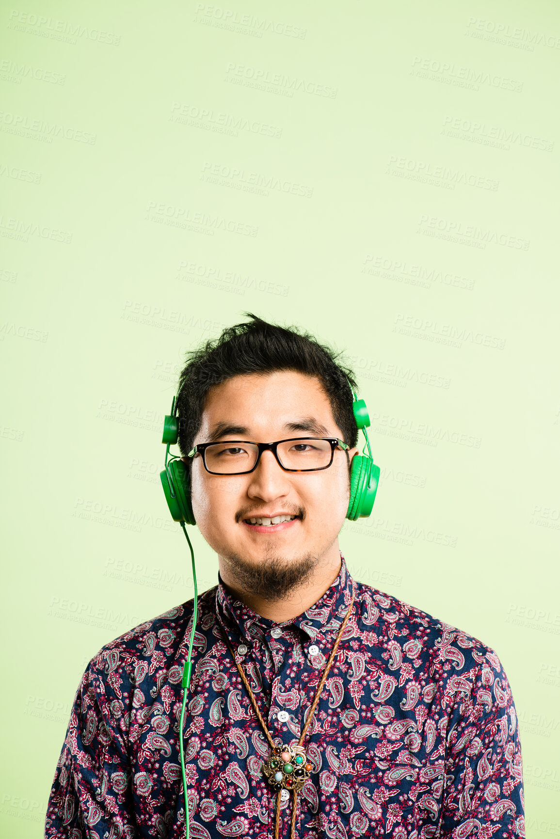 Buy stock photo Headphones, music and portrait of Asian man in studio listen to audio, streaming podcast and radio. Mockup, subscription and face of happy person for entertainment, relax or chill on green background