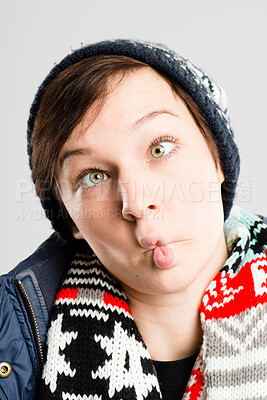 Buy stock photo Shot of an attractive young woman standing alone in the studio and pulling funny faces