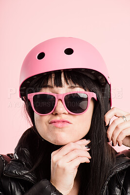 Buy stock photo Shot of an attractive young woman standing alone in the studio and putting a helmet on