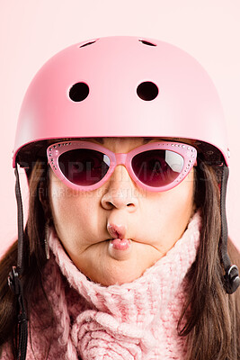 Buy stock photo Shot of an attractive young woman standing alone in the studio and pulling a funny face while wearing a helmet
