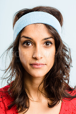 Buy stock photo Shot of an attractive young woman standing alone in the studio and posing while wearing a headband