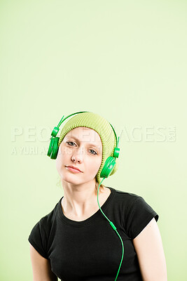 Buy stock photo Headphones, music and portrait of woman on green background listen to audio, streaming song and radio. Mockup space, subscription and face of person for entertainment, relax and podcast in studio