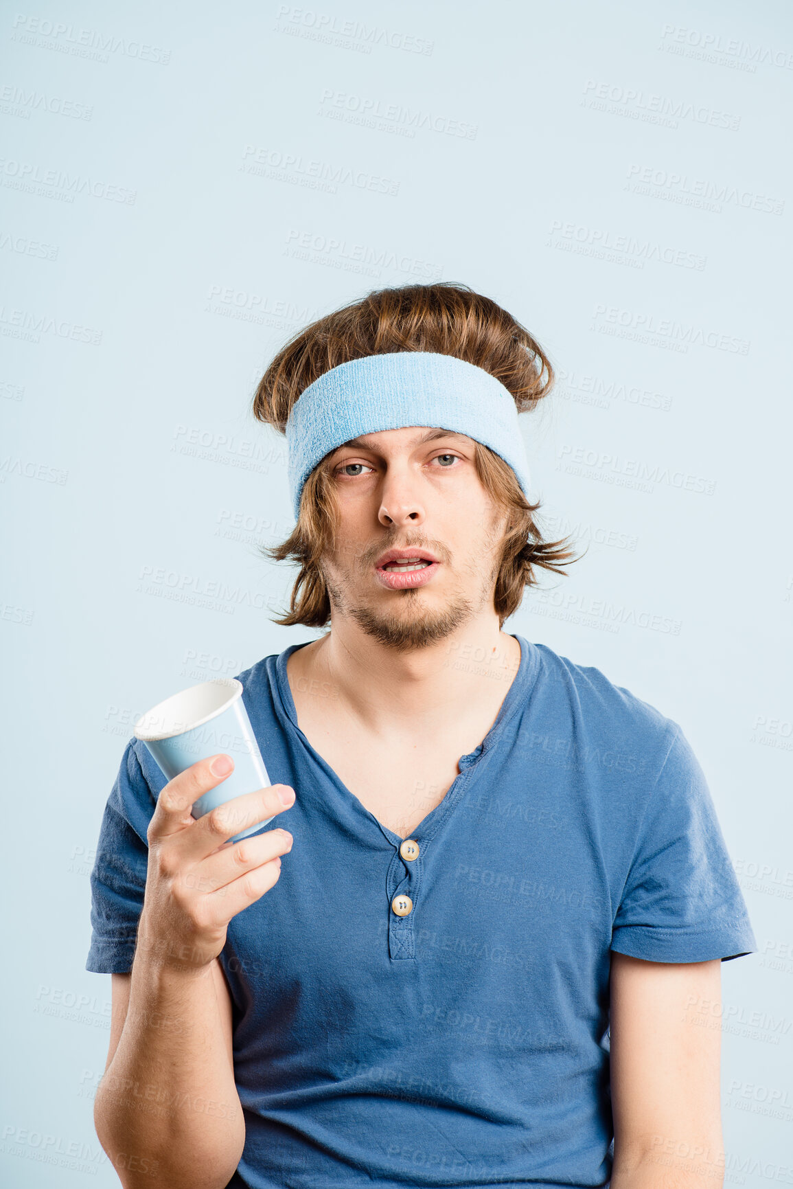 Buy stock photo Tired, man and portrait for fashion in studio with retro fitness, cup and workout thirsty of vintage headband. Fatigue, male person and dehydration, exercise burnout and mockup on blue background
