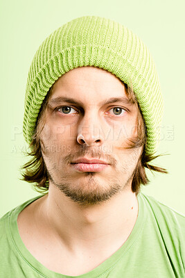 Buy stock photo Serious, casual and portrait of man with beanie, creative fashion and confidence in studio. Pride, face and male person with retro style, color and gen z designer on green background in Germany.