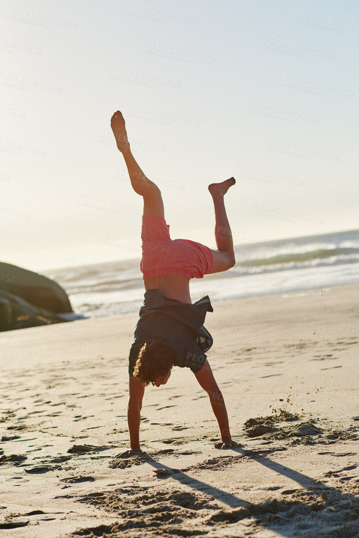 Buy stock photo Shot of a man performing a headstand at the beach