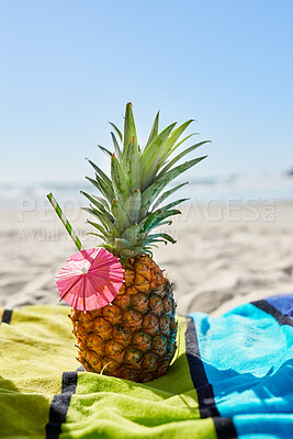 Buy stock photo Cocktail, travel and closeup of a pineapple on a beach with alcohol on a towel for vacation. Summer, ocean and tropical organic fruit with a straw or paper umbrella on the sand for a seaside holiday.