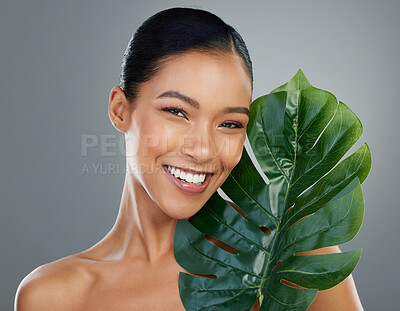 Buy stock photo Woman portrait, palm leaf and skincare in studio, cosmetics and organic treatment on gray background. Female person, vegan facial and confident for natural dermatology, clean and sustainable beauty