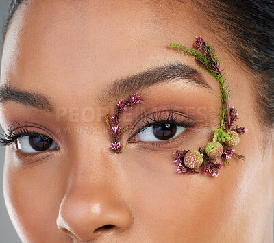 Buy stock photo Eyes, flowers and cosmetics in studio portrait, makeup and leaves by eyebrows by background. Person, model and floral plants for organic skincare, spring or closeup for facial change in Costa Rica