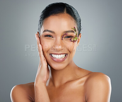 Buy stock photo Woman, flowers and cosmetics in studio portrait for makeup, happy and leaves by eye by background. Girl, person and model for organic skincare in spring, floral plants or transformation in Costa Rica