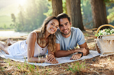 Buy stock photo Couple on picnic, portrait and relax together in nature park, happy people with travel and bonding outdoor. Happiness, man and woman lying down and commitment with trust and love in relationship