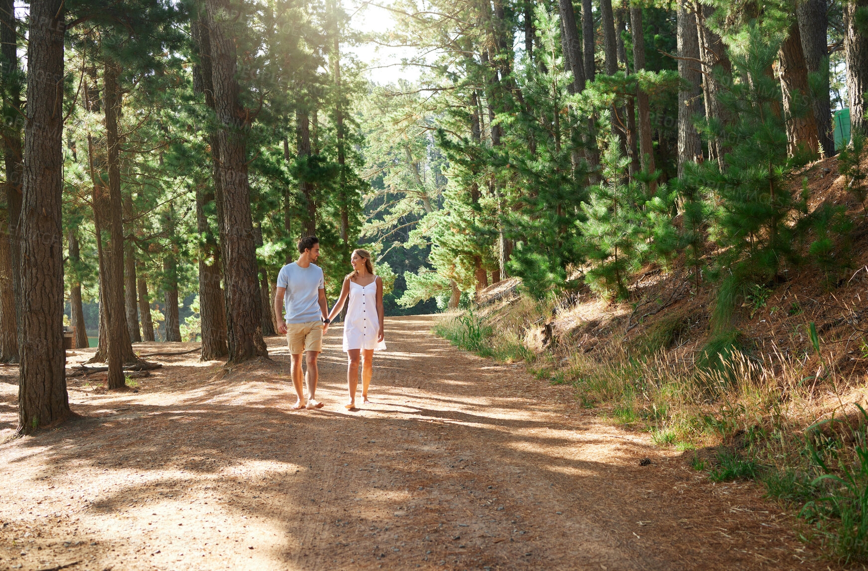 Buy stock photo Walking, happy and a couple holding hands in nature for love, a date or holiday in Switzerland. Smile, care and a young man and woman on a walk in a forest, woods or mountains during a vacation