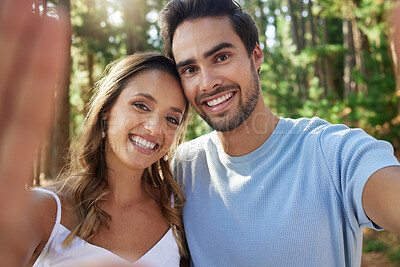 Buy stock photo Selfie, happy and portrait of a couple in nature for bonding, quality time and a memory. Smile, looking and a young man and woman taking a photo while on a date in the forest or woods together