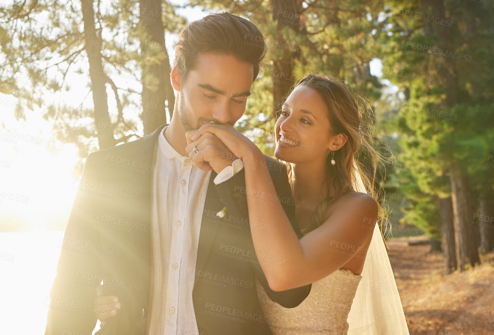 Buy stock photo Kiss, romance and couple at a nature wedding, celebration and marriage ceremony. Happy, affection and a man and woman kissing hand for loyalty, commitment and love at an event in a forest or woods