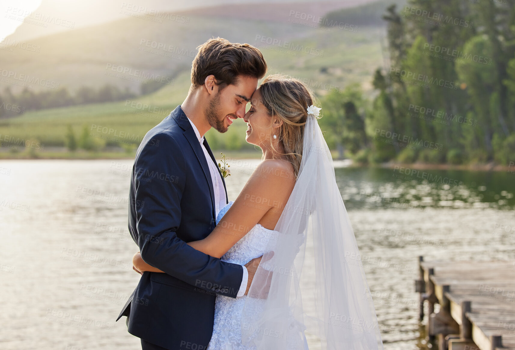 Buy stock photo Happy wedding couple, hug and love by lake for romantic honeymoon getaway in nature. Man and woman hugging touching foreheads in happiness for marriage relationship or loving embrace in the outdoors