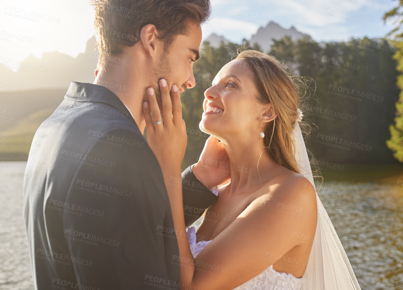 Buy stock photo Wedding, couple and lake water with a bride feeling love, care and support from marriage together. Nature, happiness and romance event of young people with a happy smile from trust and commitment