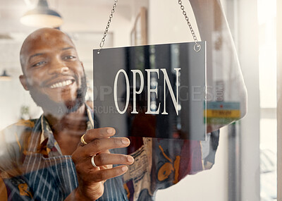 Buy stock photo Shot of a young business owner hanging up an open for business sign