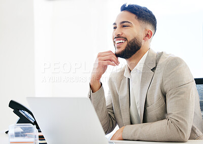 Buy stock photo Shot of a handsome young businessman sitting alone in the office and using his laptop