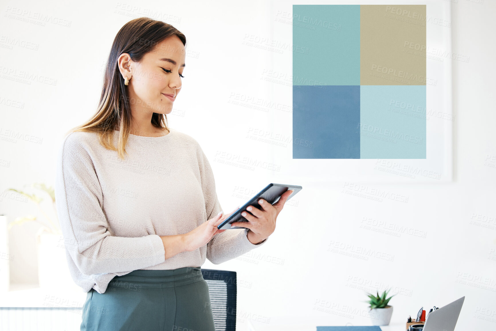 Buy stock photo Shot of an attractive young businesswoman standing alone in the office and using a digital tablet