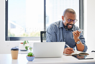 Buy stock photo Shot of a handsome mature businessman sitting alone in the office and using his cellphone while writing notes