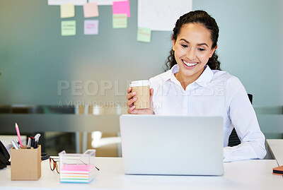 Buy stock photo Shot of an attractive young businesswoman sitting alone in the office and enjoying a coffee while using her laptop