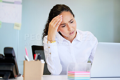 Buy stock photo Shot of an attractive young businesswoman sitting alone in the office and feeling stressed while using her laptop