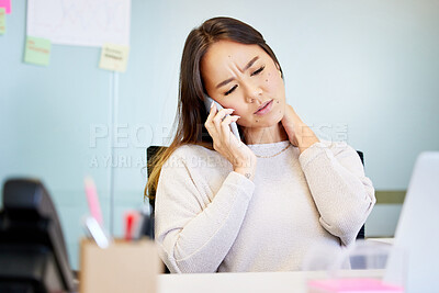 Buy stock photo Shot of an attractive young businesswoman sitting alone in the office and suffering from neck pain while using technology