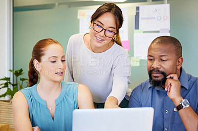 Buy stock photo Shot of a diverse group of businesspeople brainstorming while using a laptop in the office