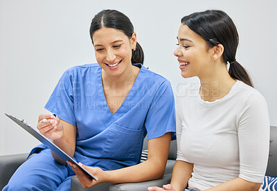 Buy stock photo Shot of a young woman filling out a clipboard in her dentists office