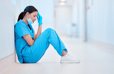 Buy stock photo Shot of a young female nurse sitting on the floor looking depressed