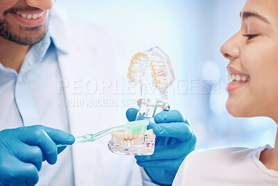 Buy stock photo Shot of a dentist demonstrating the best way to brush teeth to a patient