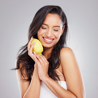 Buy stock photo Cropped shot of an attractive young woman posing with a lemon against a grey background