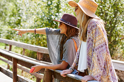 Buy stock photo Friends, happy and women in nature pointing to view on holiday, vacation and adventure outdoors. Travel, smile and people on bridge in park, forest or woods for bonding, relax and fun on weekend