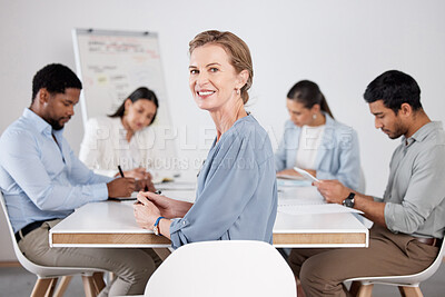 Buy stock photo Cropped portrait of an attractive mature businesswoman sitting in the boardroom during a meeting with her colleagues