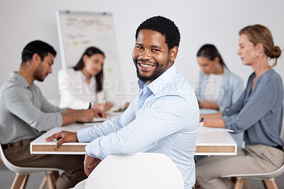 Buy stock photo Cropped portrait of a handsome young businessman sitting in the boardroom during a meeting with her colleagues