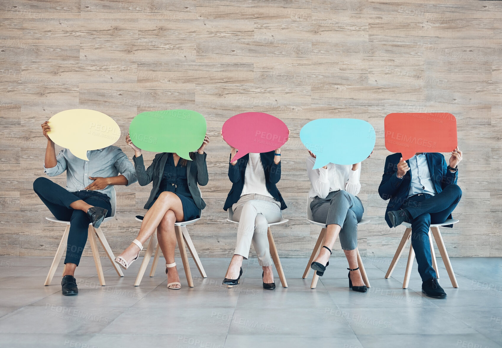 Buy stock photo Shot of an unrecognisable group of businesspeople sitting in a row together and holding posters