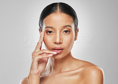 Buy stock photo Studio portrait of an attractive young woman posing against a grey background