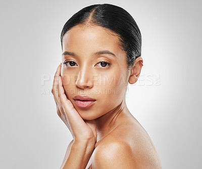 Buy stock photo Studio portrait of an attractive young woman posing against a grey background