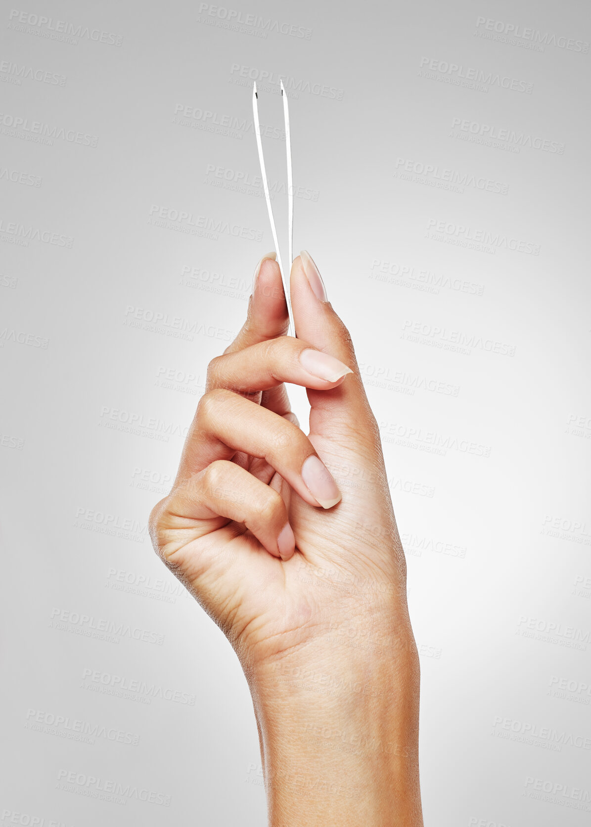 Buy stock photo Studio shot of an unrecognisable woman holding a tweezer against a grey background