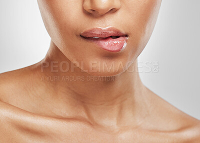 Buy stock photo Studio shot of an unrecognisable woman biting her lip against a grey background