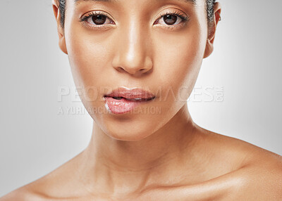 Buy stock photo Studio portrait of an attractive young woman biting her lip against a grey background