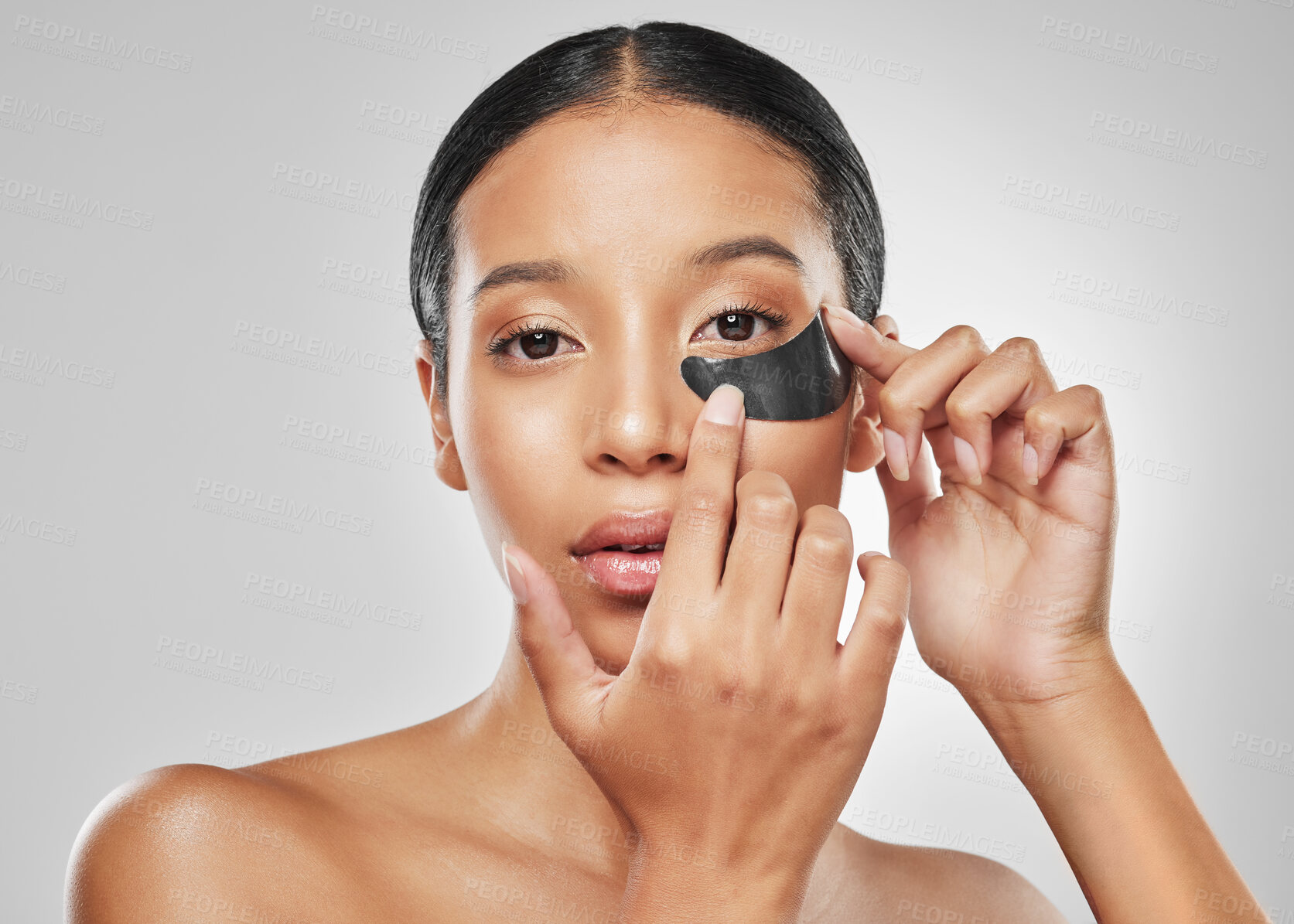 Buy stock photo Studio portrait of an attractive young woman wearing an under eye patch against a grey background