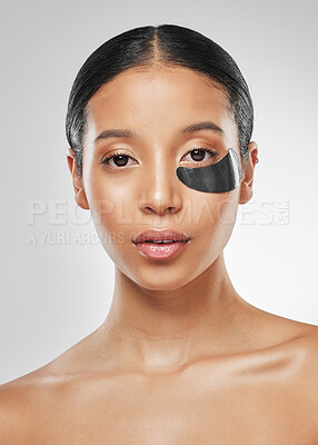 Buy stock photo Studio portrait of an attractive young woman wearing an under eye patch against a grey background