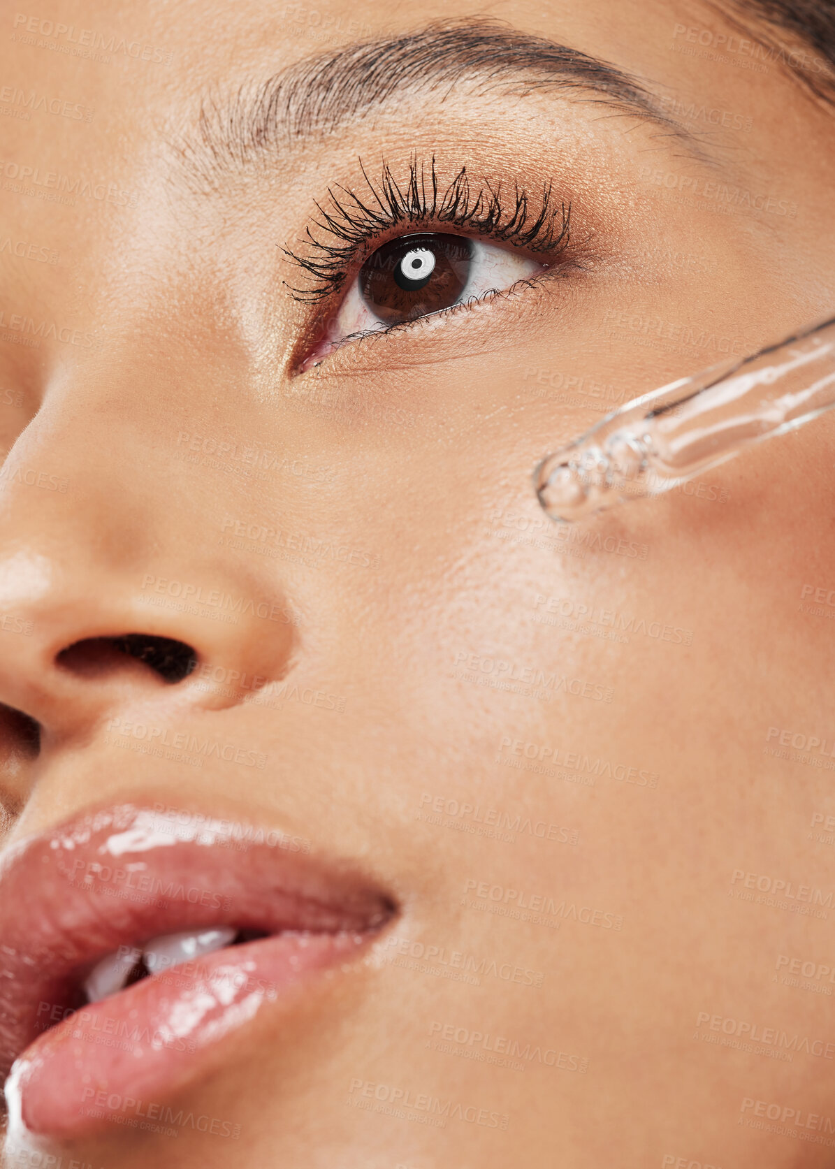 Buy stock photo Shot of an attractive young woman applying serum to her face