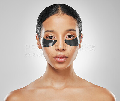 Buy stock photo Studio portrait of an attractive young woman wearing under eye patches against a grey background