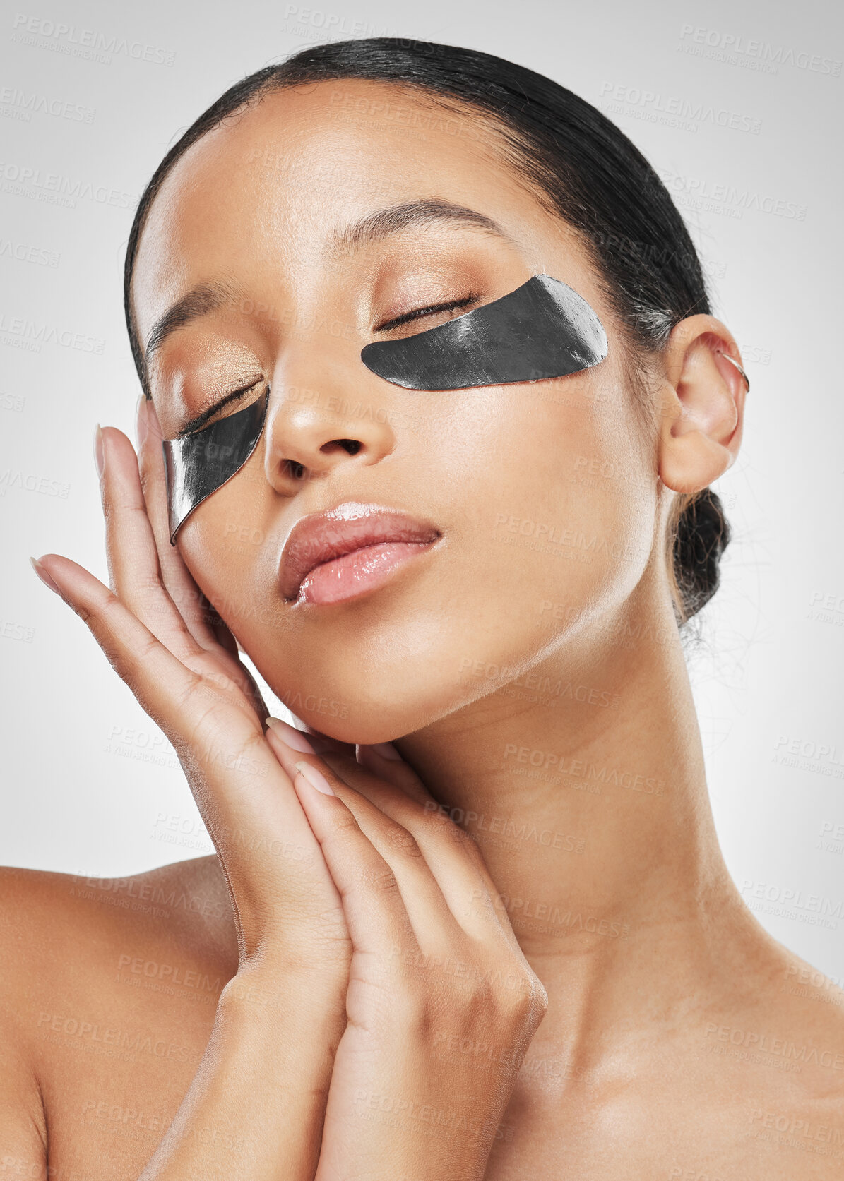 Buy stock photo Studio shot of an attractive young woman wearing under eye patches against a grey background