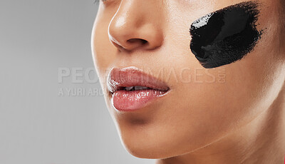 Buy stock photo Studio shot of an unrecognisable woman wearing some charcoal face mask against a grey background